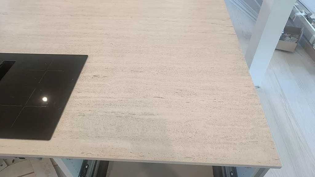 Matt Dekton Marmorio köksbänkskiva med synlig kant, svart häll och ljus travertinliknande yta i Uddevalla.