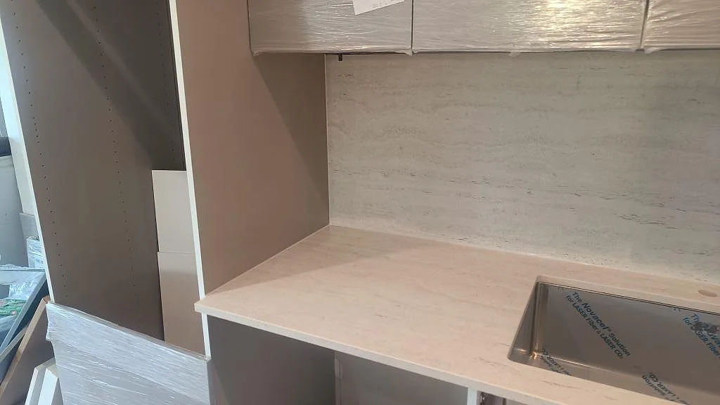 Matt Dekton Marmorio bänkyta med matchande stänkskydd och rostfri diskho vid väggsidan i ett kök i Uddevalla.