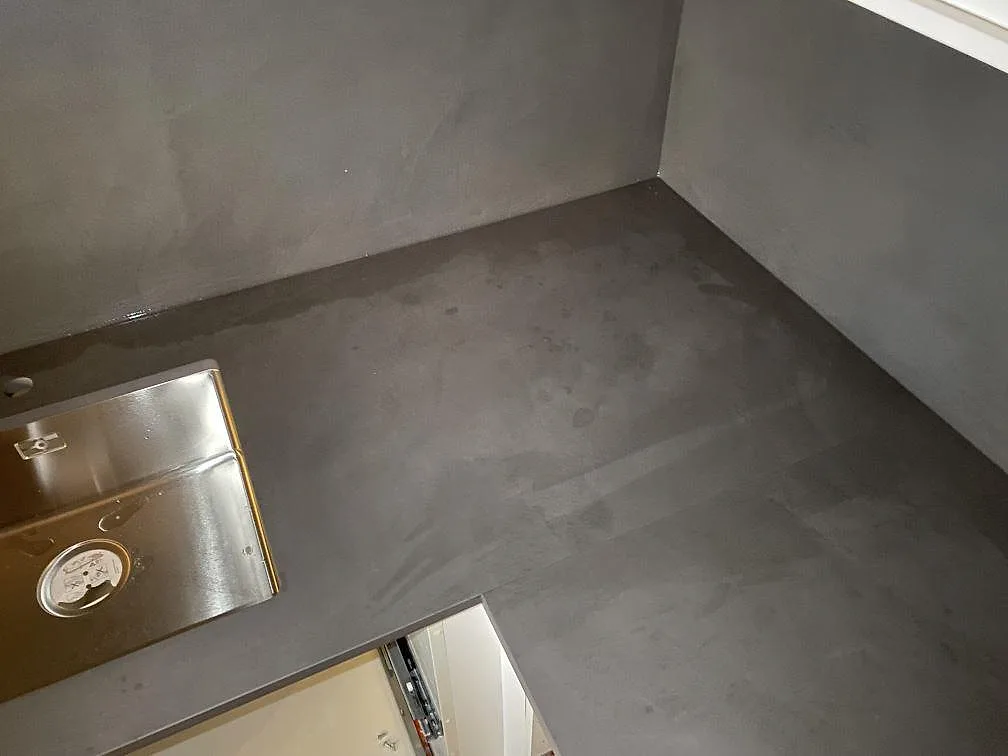 Närbild på matt Dekton Micron keramik vid diskhohörn och vägg i ett kök under montering i Bunkeflostrand.