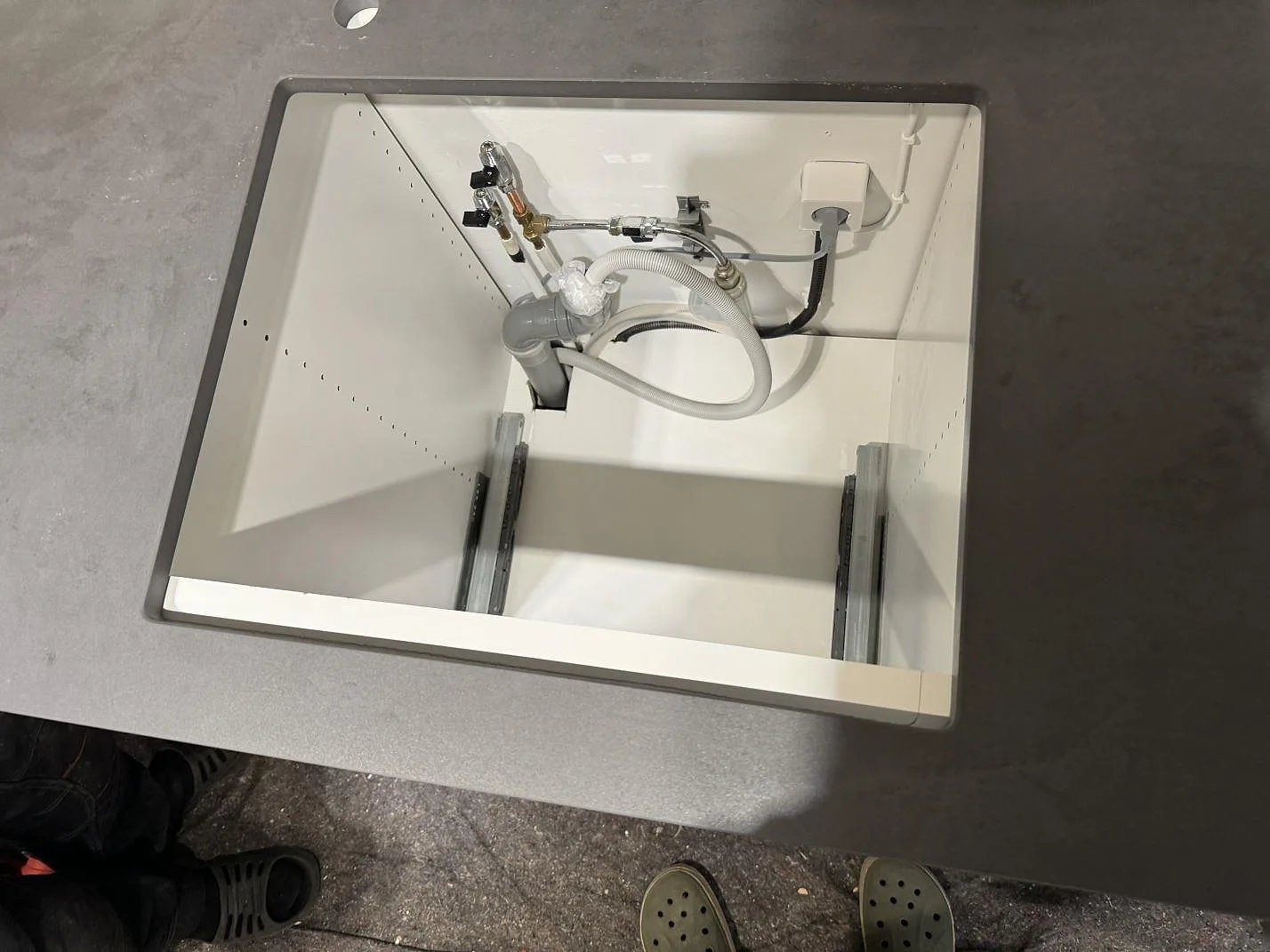 Matt Dekton Micron bänkskiva med öppet urtag, blandarhål och synlig VVS under montering i Olofström.