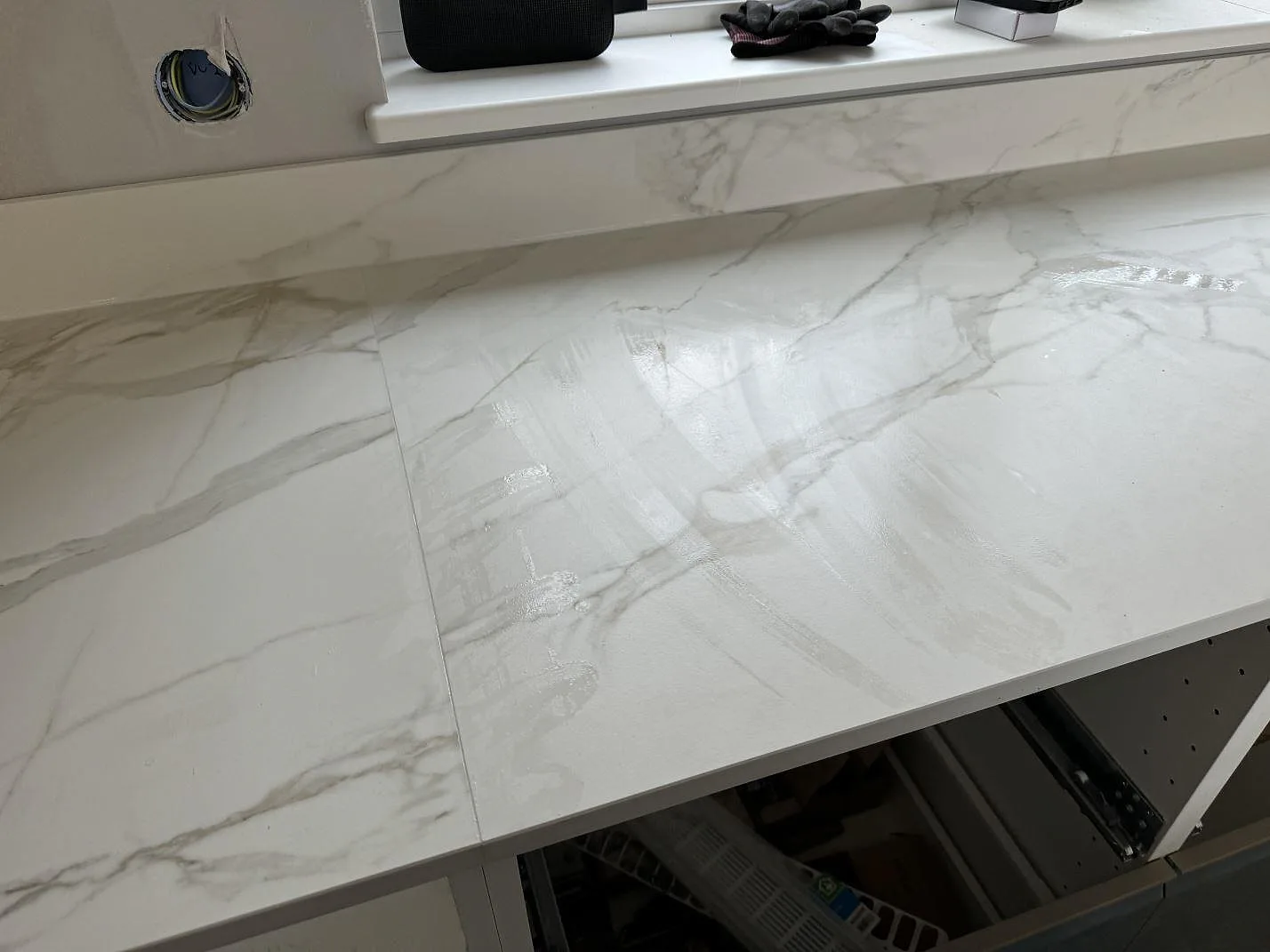 Fönstersida med köksbänkskiva i matt Dekton Morpheus Velvet, låg stänkkant och öppna stommar under montering i Billesholm.