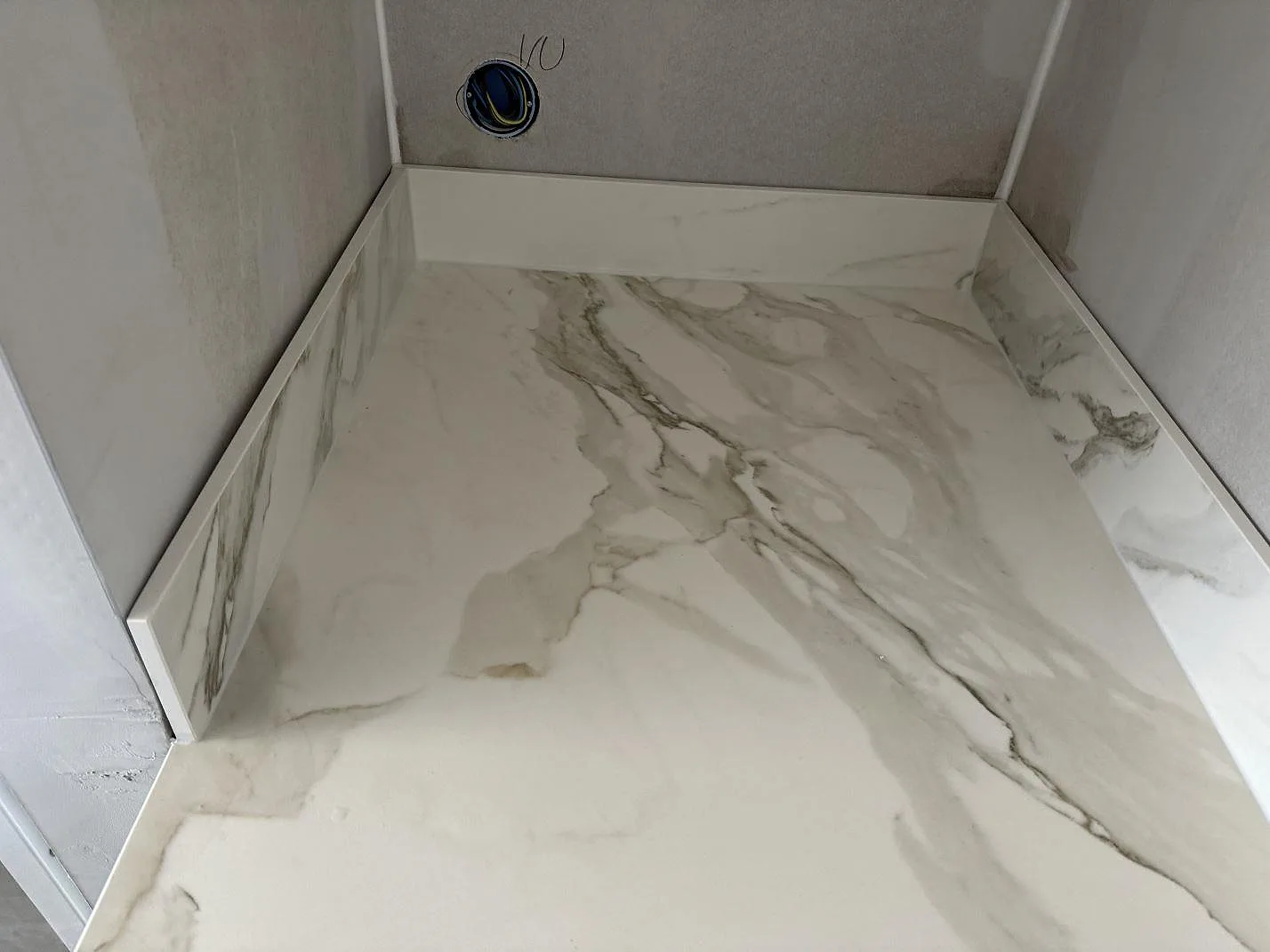 Närbild på bänkskiva och uppvikt kant i matt Dekton Morpheus Velvet med ljus marmorerad ådring i ett kök i Billesholm.