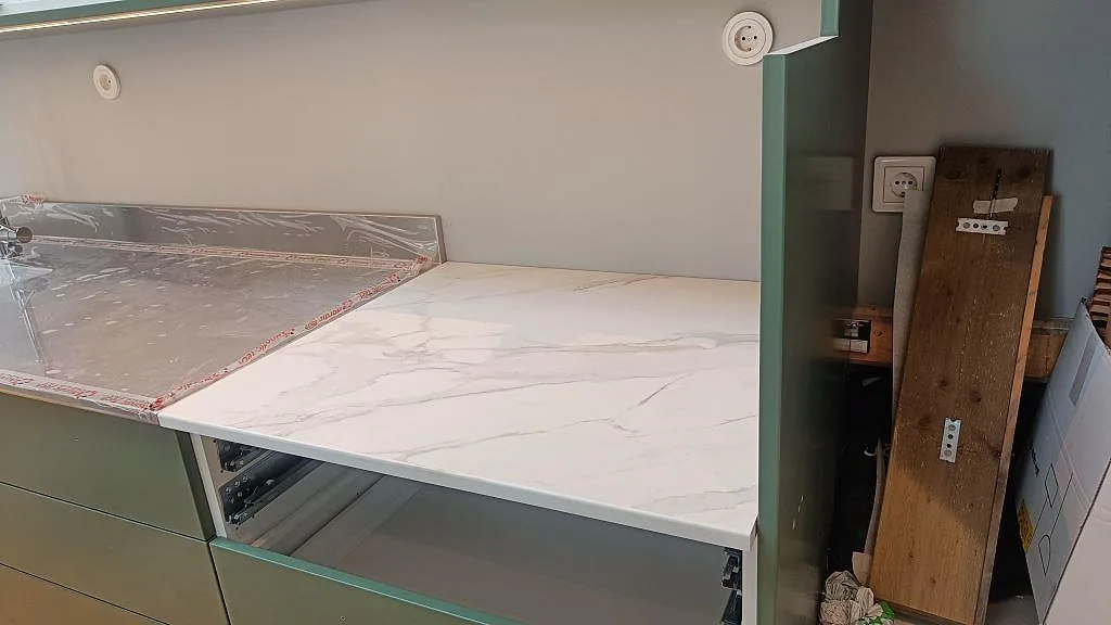 Närbild på Dekton Morpheus Velvet bänkskiva, matt vit keramik med mjuk grå ådring vid köksstommar i Kungsbacka.