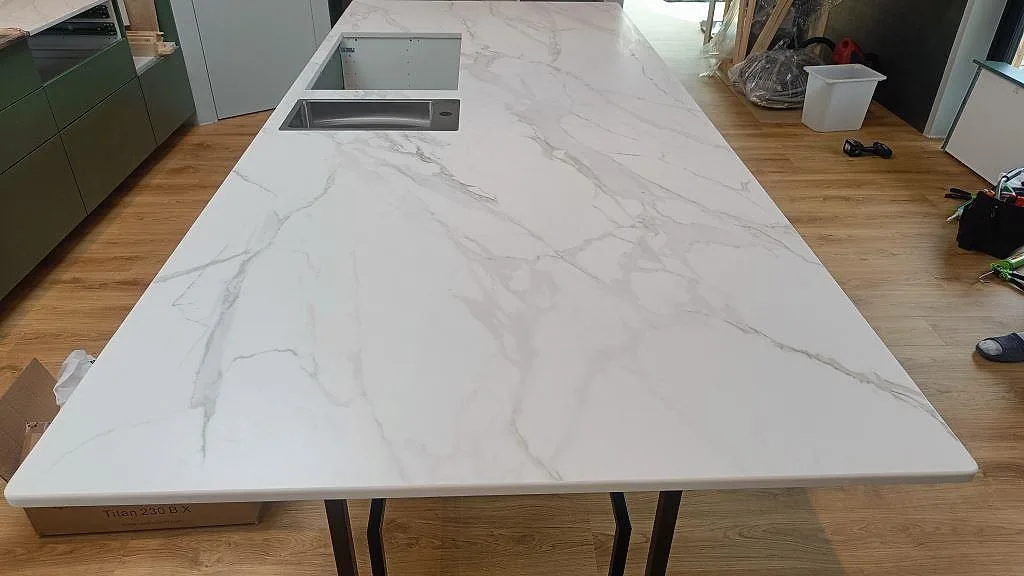 Stor köksö i matt Dekton Morpheus Velvet med rostfri diskho, utskärning och tydlig ådring i ett kök i Kungsbacka.