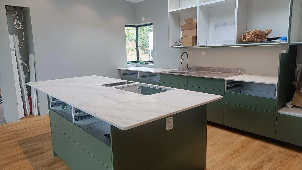 Köksbänkskiva i matt Dekton Morpheus Velvet, vit keramik med grå ådring, monterad på stor köksö och bänkar i Kungsbacka.