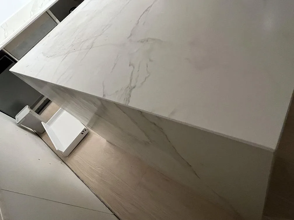 Detalj av köksö i keramisk Dekton Morpheus Velvet där bänkskiva och sidostycke möts under montering i Södertälje.