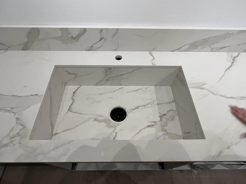 Underlimmad diskho i matt keramisk Dekton Morpheus Velvet med låg stänkkant och marmorerad bänkskiva i Södertälje.