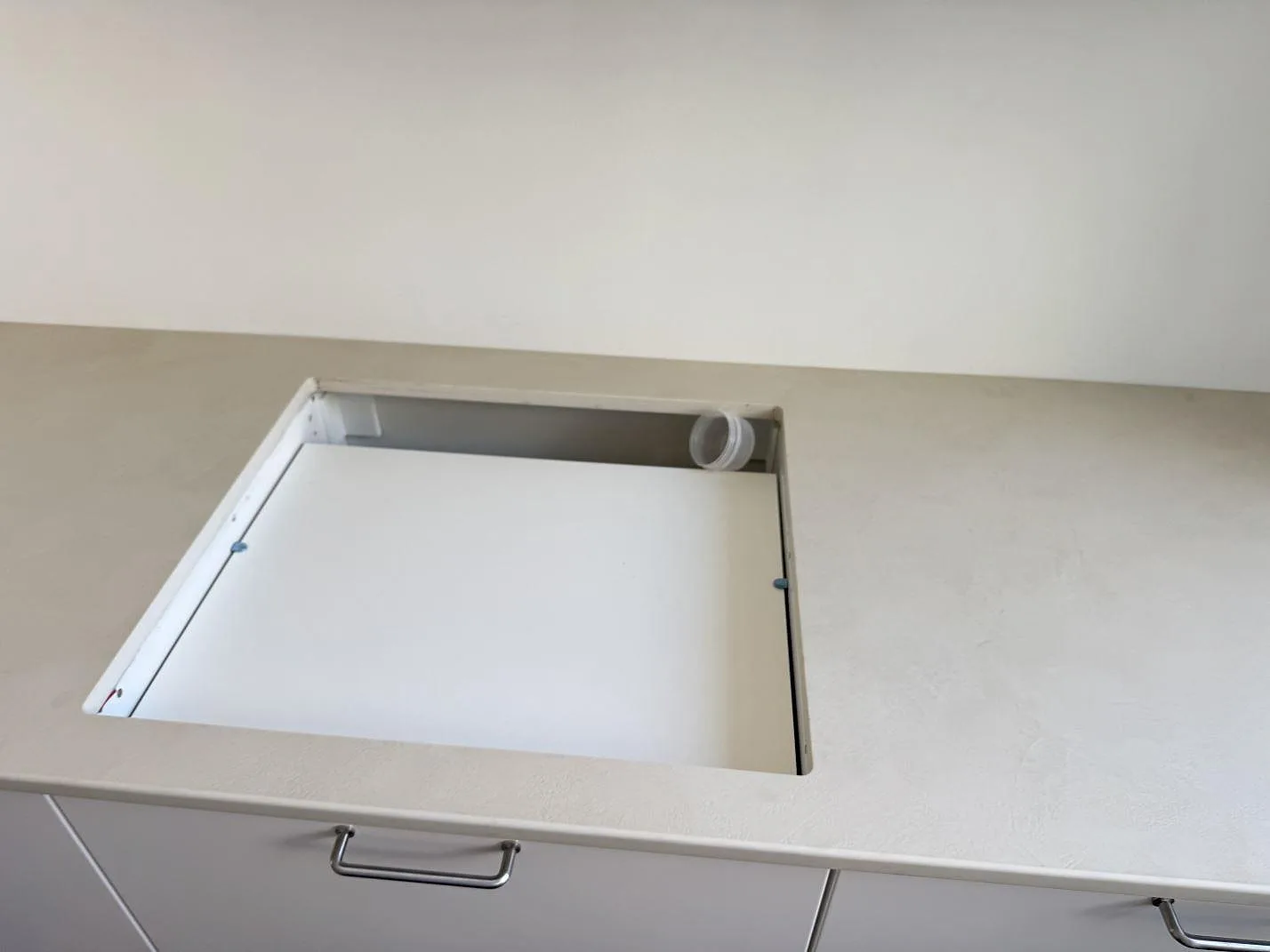 Detalj av ljus keramisk köksbänkskiva i Dekton Nacre Velvet med skyddad diskhoöppning i Frederiksberg.