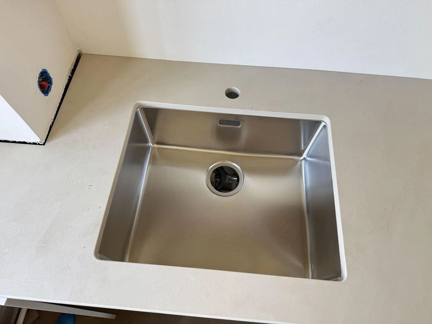 Närbild på underlimmad rostfri diskho i matt Dekton Nacre Velvet, en ljus keramisk köksbänkskiva i Frederiksberg.