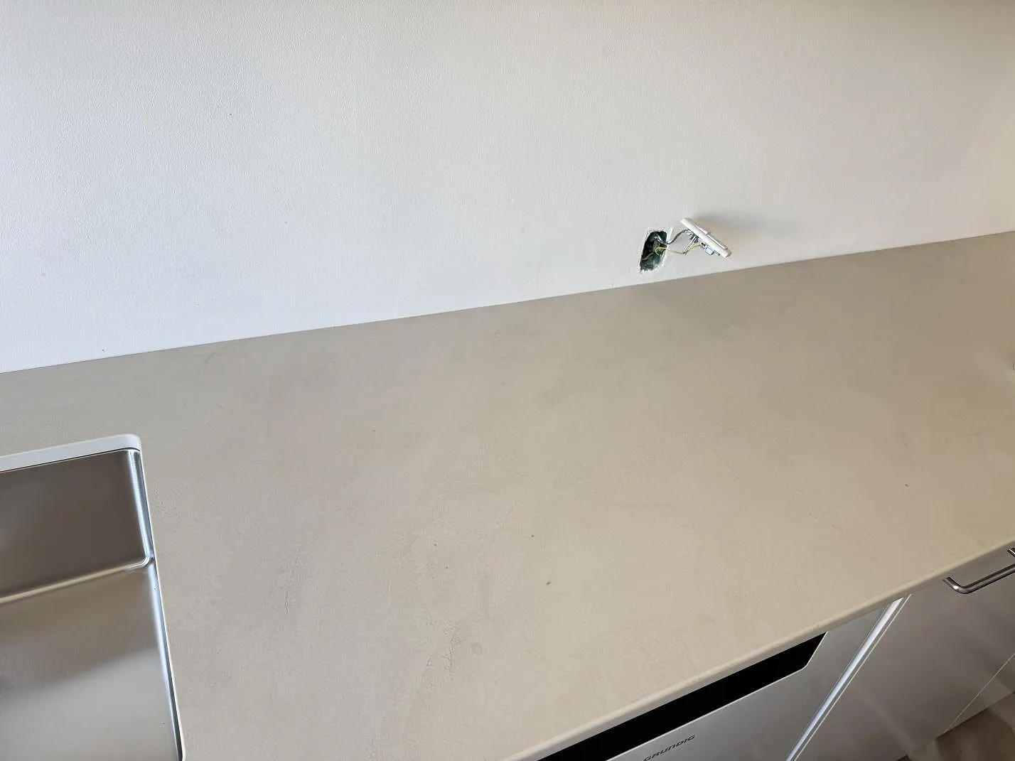 Lång arbetsyta i matt Dekton Nacre Velvet, keramisk köksbänkskiva med diskho i ena änden i Frederiksberg.