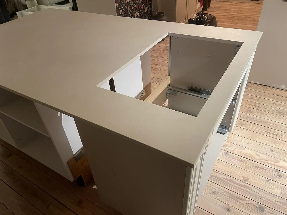 Detalj av hällurtag i en köksö av matt Dekton Nacre Velvet med ljus keramisk yta i Immeln.