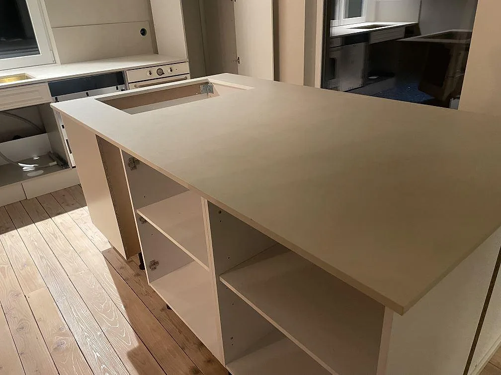Köksö i matt Dekton Nacre Velvet, keramik, med bred arbetsyta och hällurtag under montering i Immeln.