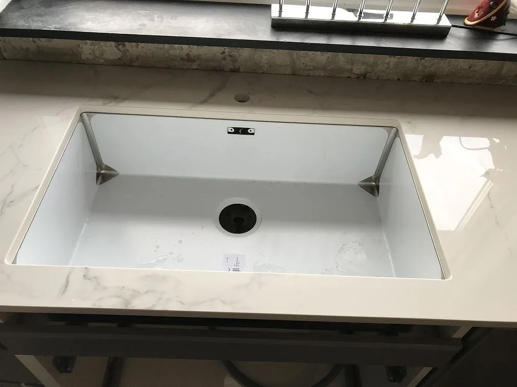 Underlimmad vit diskho i en polerad Dekton Natura bänkskiva i ett kök i Bara.