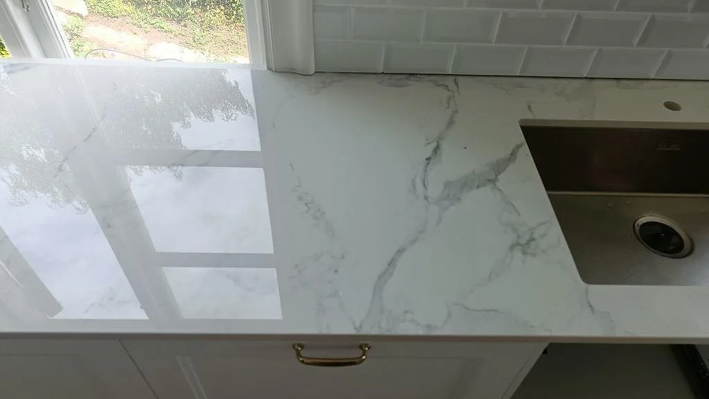 Polerad Dekton Natura bänkskiva med grå ådring och underlimmad rostfri diskho i ett kök i Karlskrona.