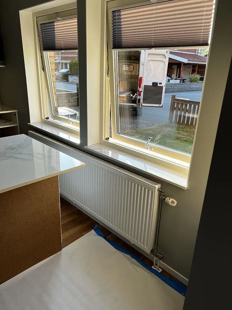 Fönsterparti med fönsterbänk i polerad Dekton Natura keramik och intilliggande köksö i Landskrona.