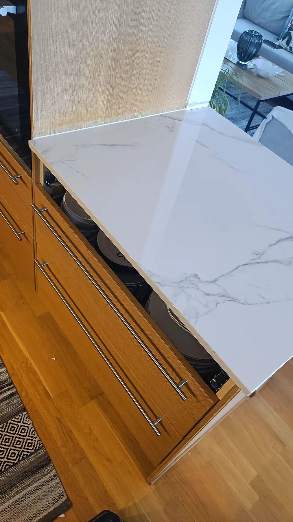 Närbild på polerad Dekton Natura som köksbänkskiva mot varm träinredning, med grå ådring i Limhamn.