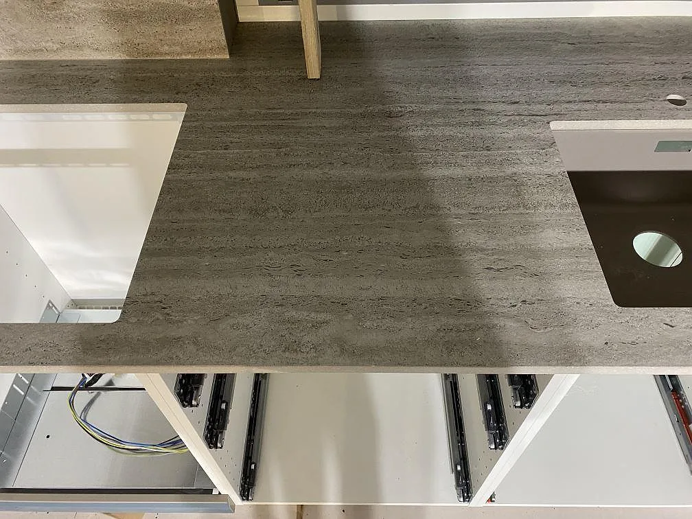 Närbild av matt Dekton Nebu keramik i ett kök i Borrby, med gråbeige ådring och synliga urtag i bänkskivan.