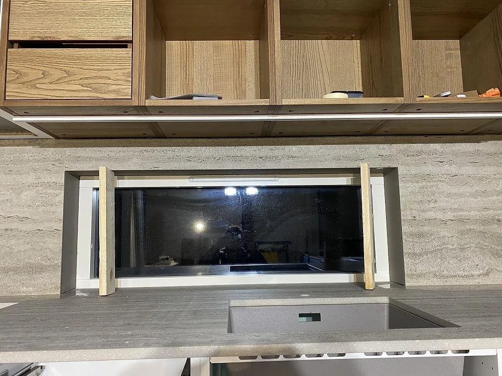 Kök i Borrby med matt Dekton Nebu i keramik som bänkskiva och stänkskydd runt fönster, med mörk diskho synlig.