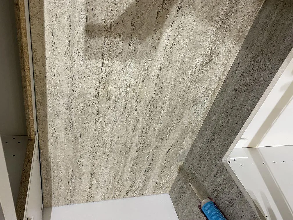 Närbild av installerad matt Dekton Nebu keramik i ett kök i Borrby, med gråbeige ådring och kant mot skåpstomme.