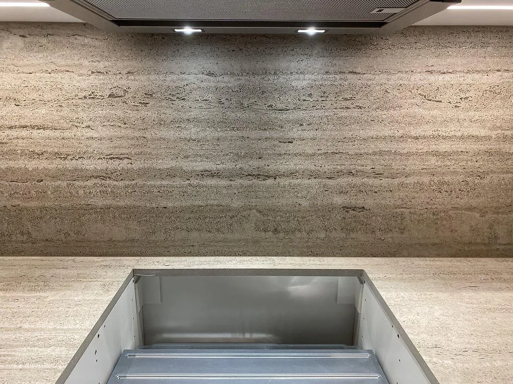 Detalj av matt Dekton Nebu bänkskiva i kök med urtag och stänkskydd i varmt gråbeige keramik, Upplands Väsby.