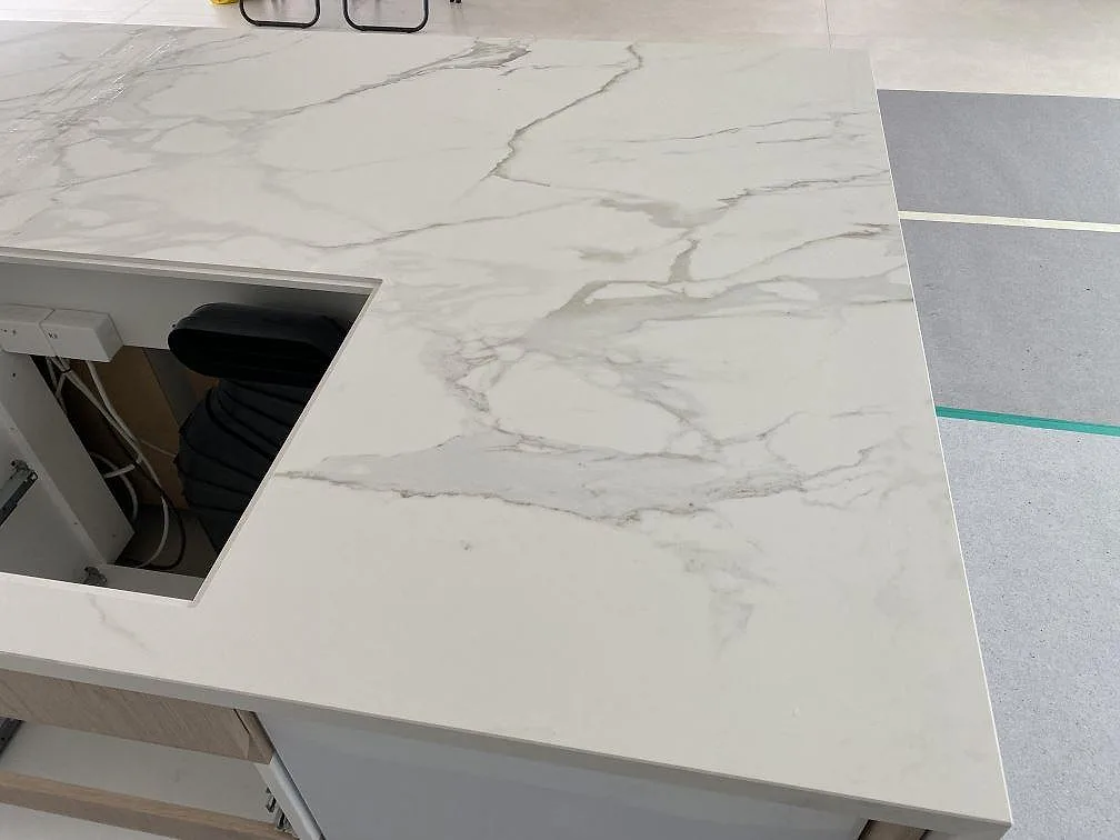 Dekton Neural i matt keramik som köksbänkskiva, med grå marmorerad ådring och öppning i Ålsgårde.