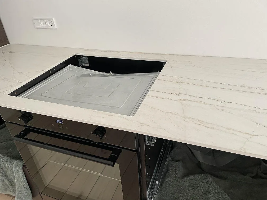 Matt Dekton Neural runt en svart induktionshäll, 12 mm keramisk köksbänkskiva under montering i Frederiksberg.