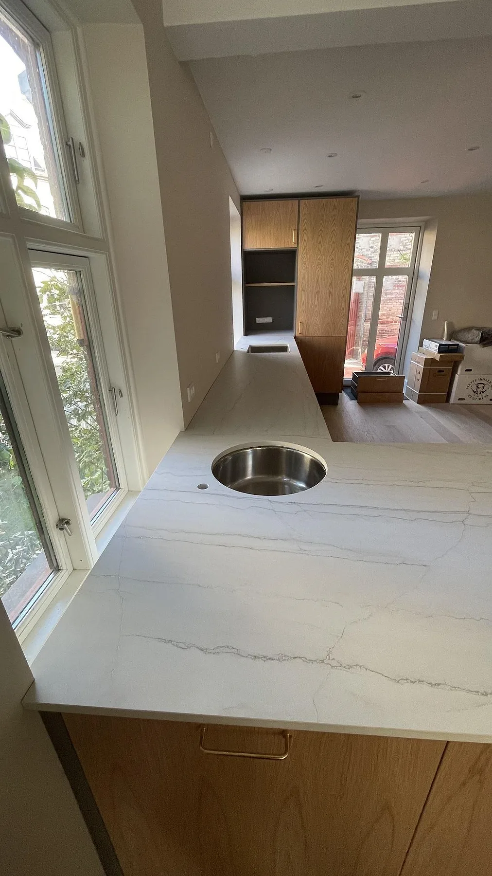 Rund underlimmad rostfri diskho i en matt Dekton Neural köksbänkskiva med grå ådring i København V.