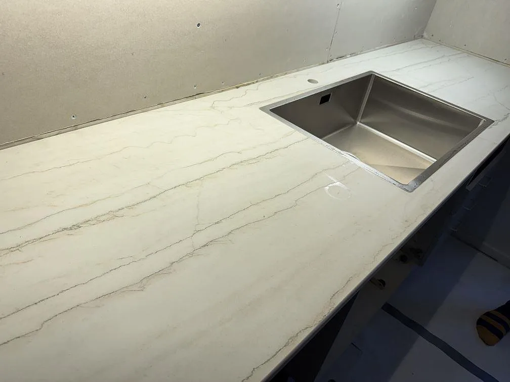 Närbild av matt Dekton Neural som köksbänkskiva med rostfri diskho och tydlig grå ådring i Lund.