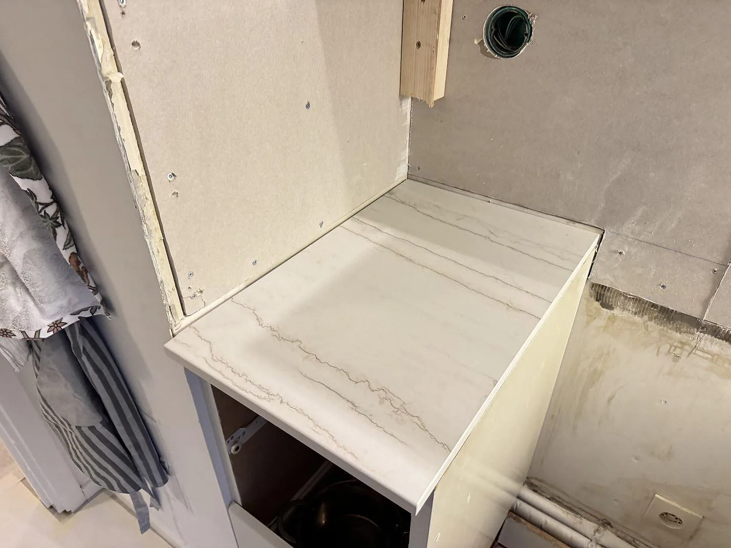 Kortare bänkparti i matt Dekton Neural med grå ådring, monterat mot vägg i ett kök under arbete i Lund.