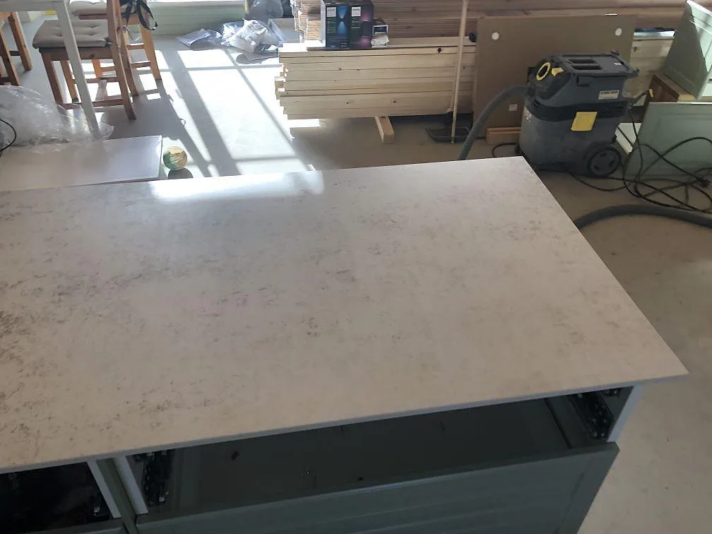 Köksö i Dekton Nilium ovanifrån, matt greige sten med subtil ådring, i ett kök under inredning i Båstad.