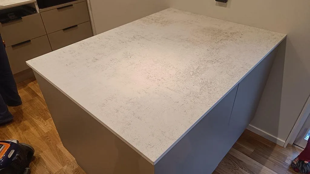 Stor köksö i matt Dekton Nilium med ljus betongliknande struktur i ett kök i Hörby.