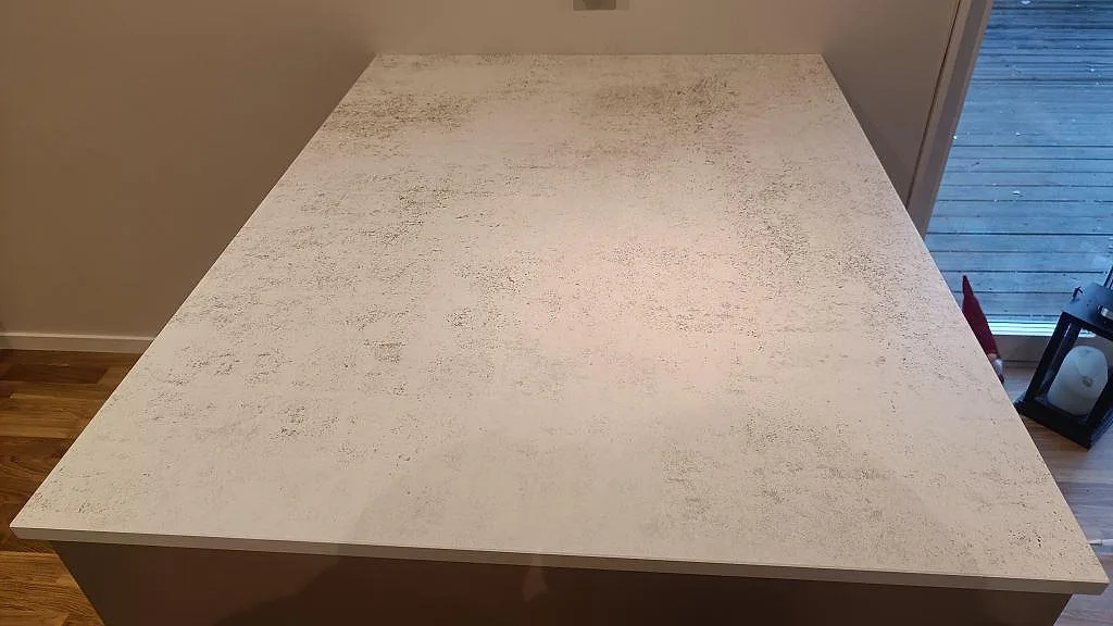 Köksö i Dekton Nilium, matt, med rak kant och ljus melerad yta under montering i Hörby.