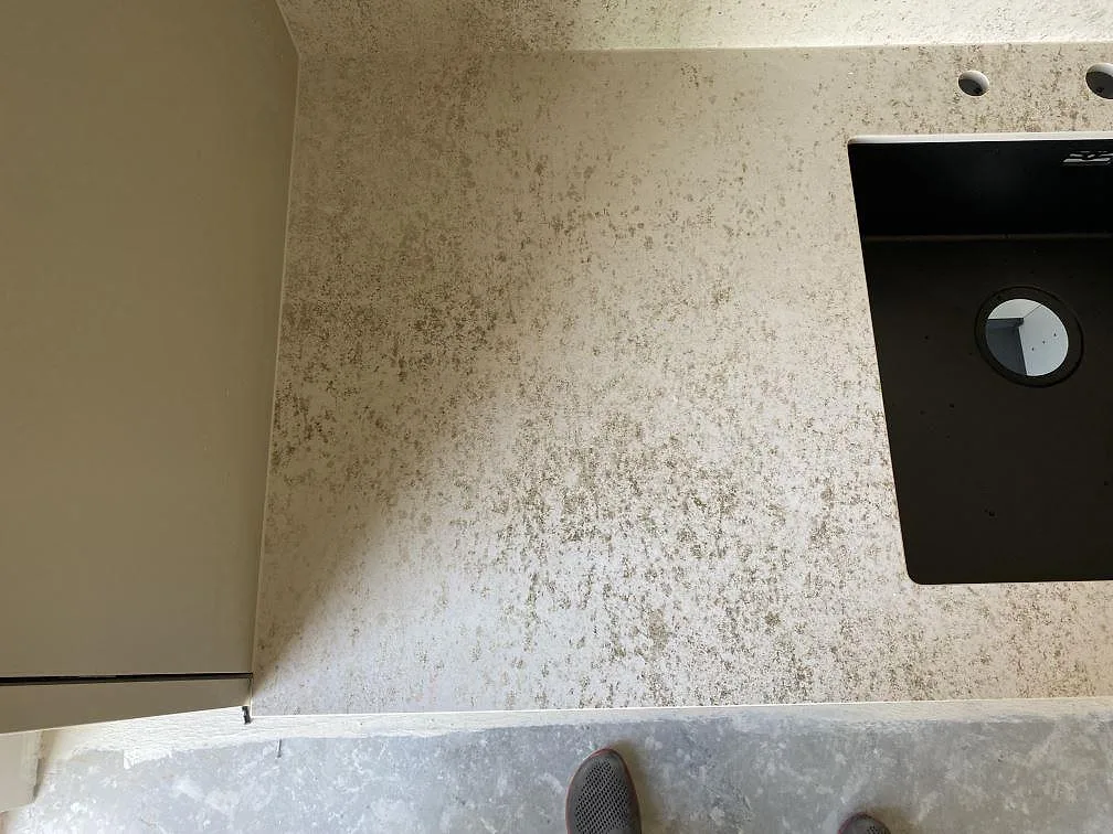 Närbild av matt Dekton Nilium bänkskiva och stänkvägg vid den svarta hon under köksmontering i Tygelsjö.