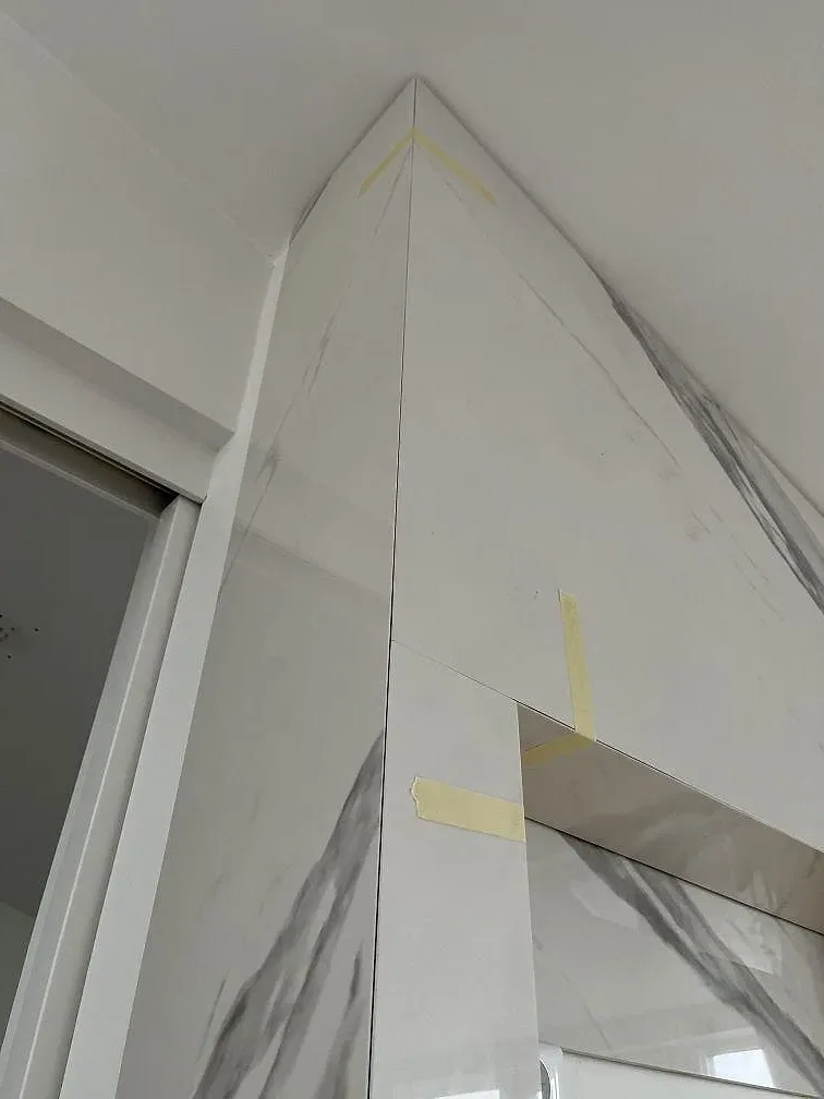 Detalj av polerad Dekton Olimpo bänkskiva med gerad kant och tydlig grå ådring i ett kök i Göteborg.