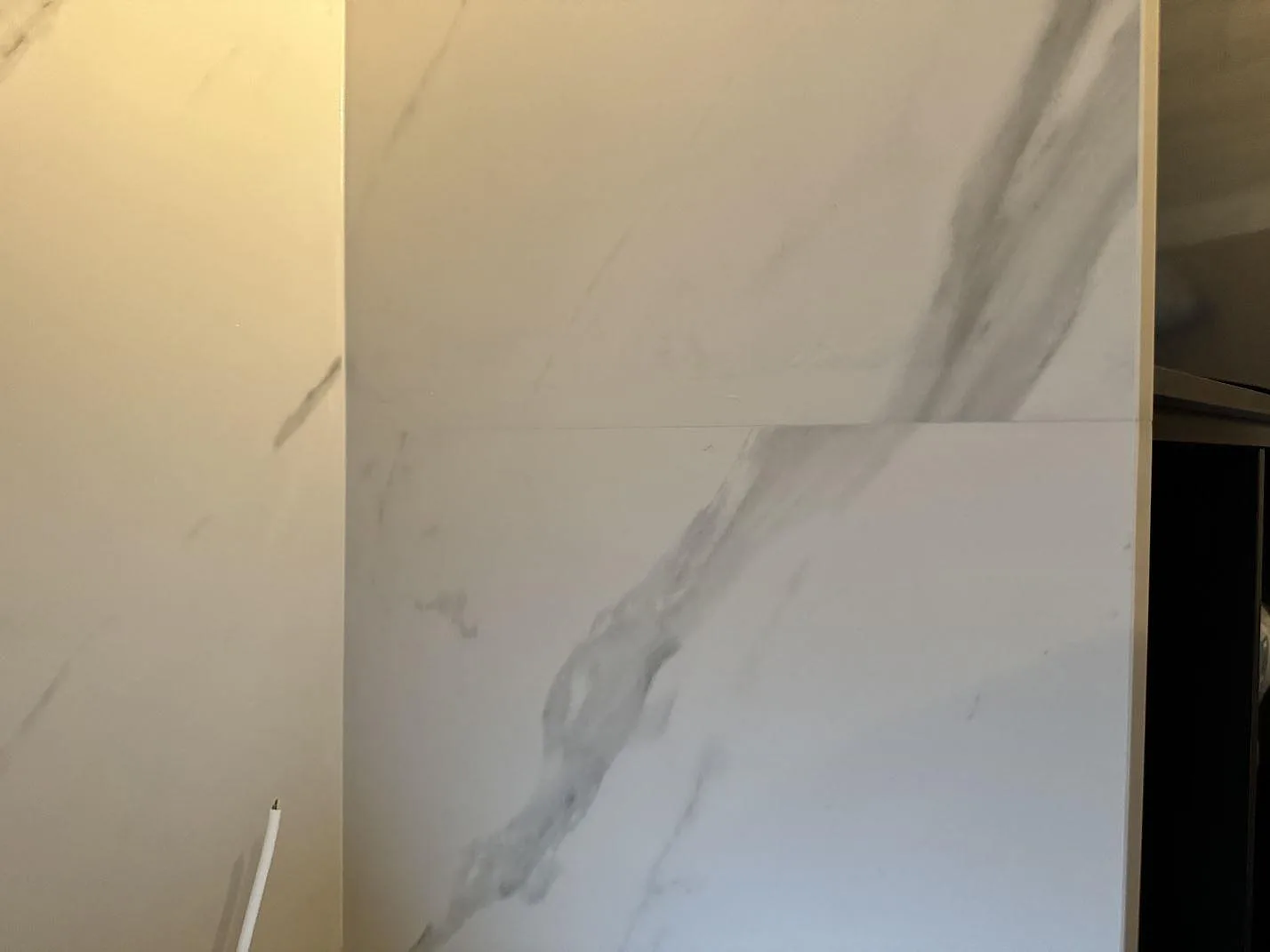 Närbild av matt Dekton Opera Velvet som bänkskiva och stänkskydd med sammanhängande grå ådring i Malmö.