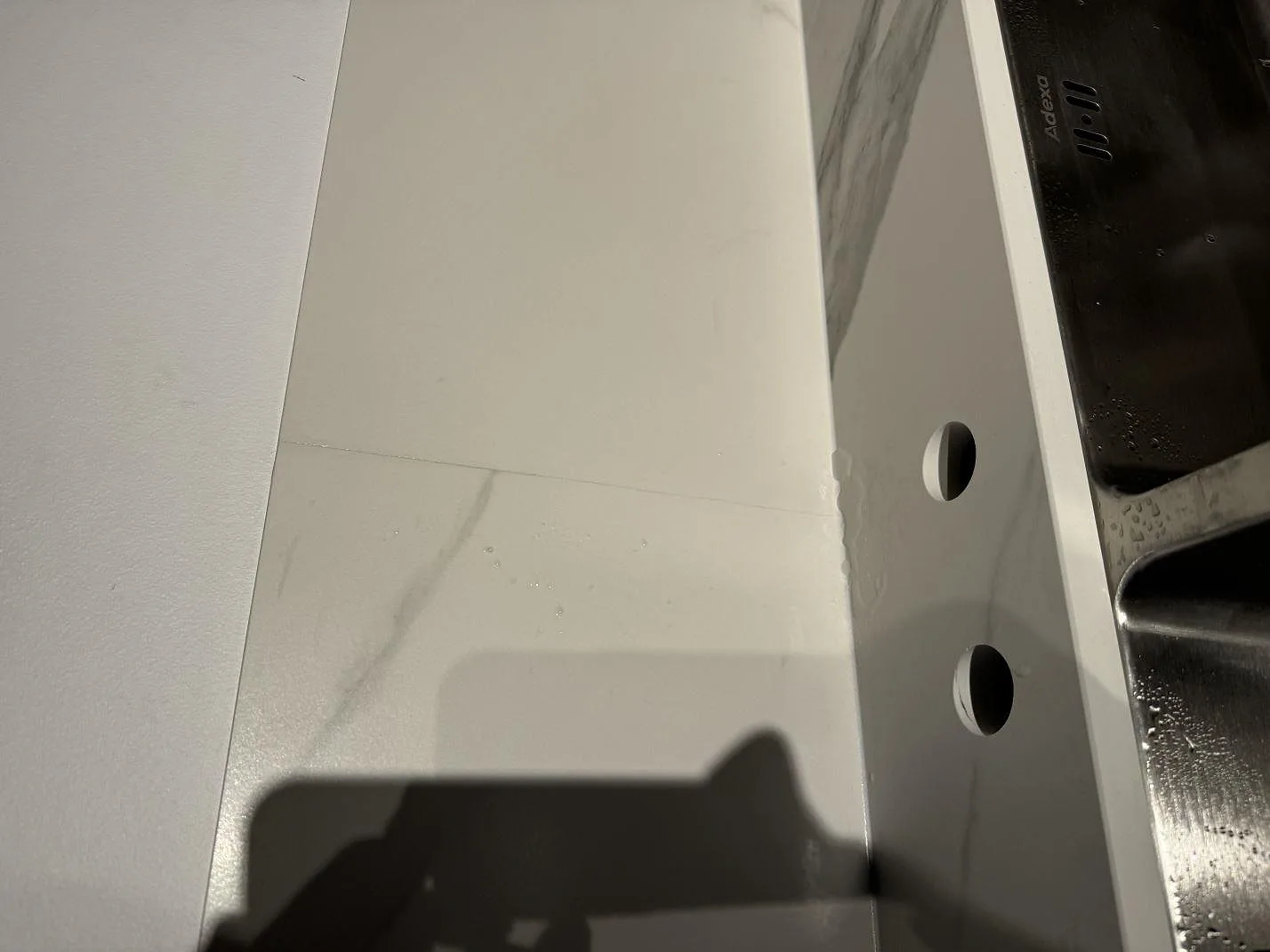 Detalj av matt Dekton Opera Velvet vid diskho och förborrade hål för blandare i ett kök i Malmö.