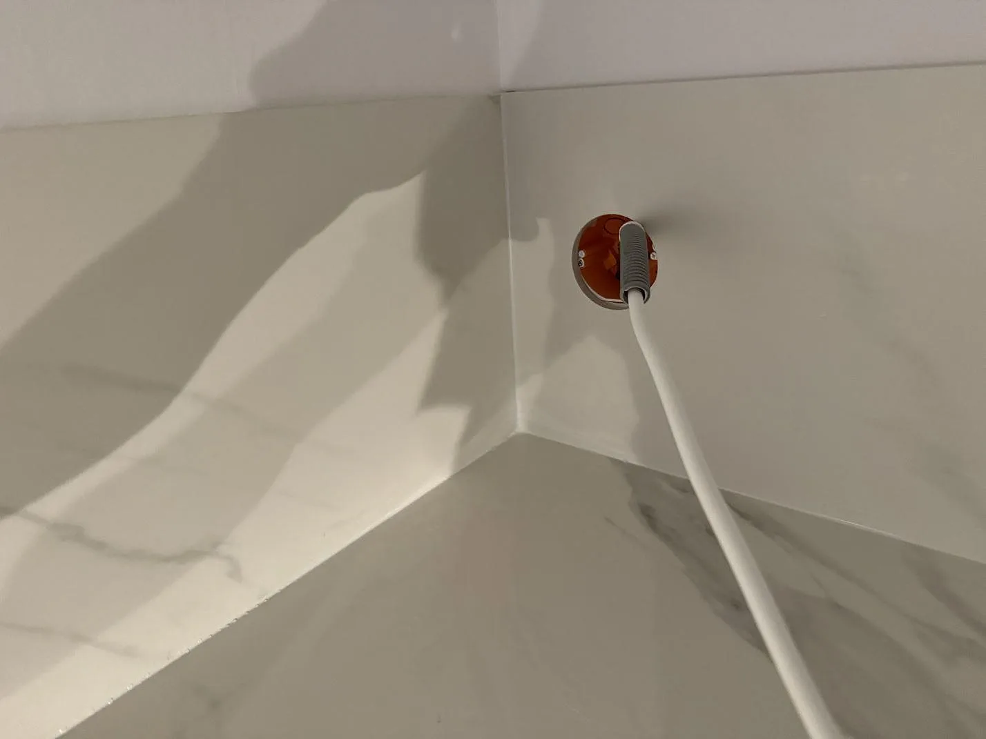 Tät detalj av stänkskydd och bänkskiva i matt Dekton Opera Velvet vid vägguttag i Malmö.