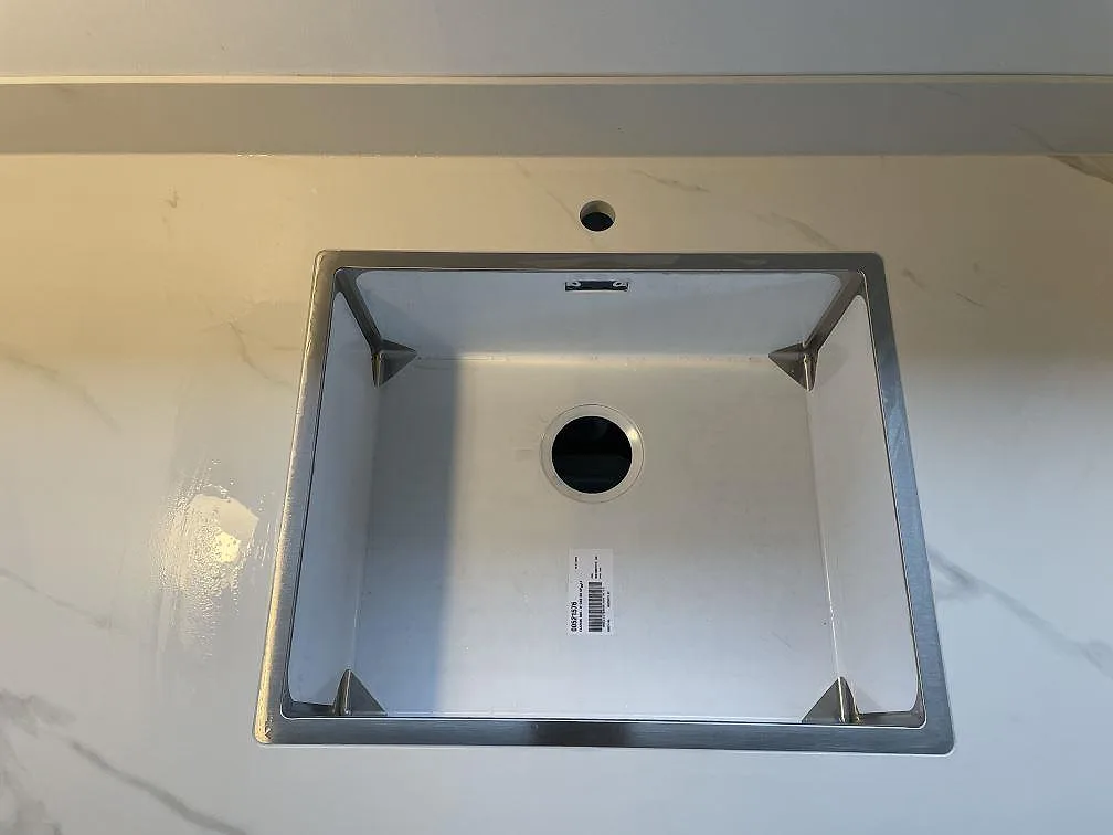 Ovanifrånbild av vit matt Dekton Opera Velvet bänkskiva i keramik med rostfri underlimmad diskho i Solroed Strand.