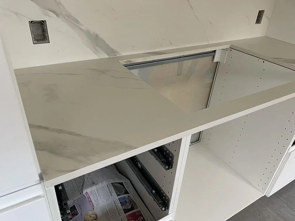 Detalj av matt Dekton Opera Velvet keramik med hällöppning, grå ådring och vita köksstommar i Solroed Strand.