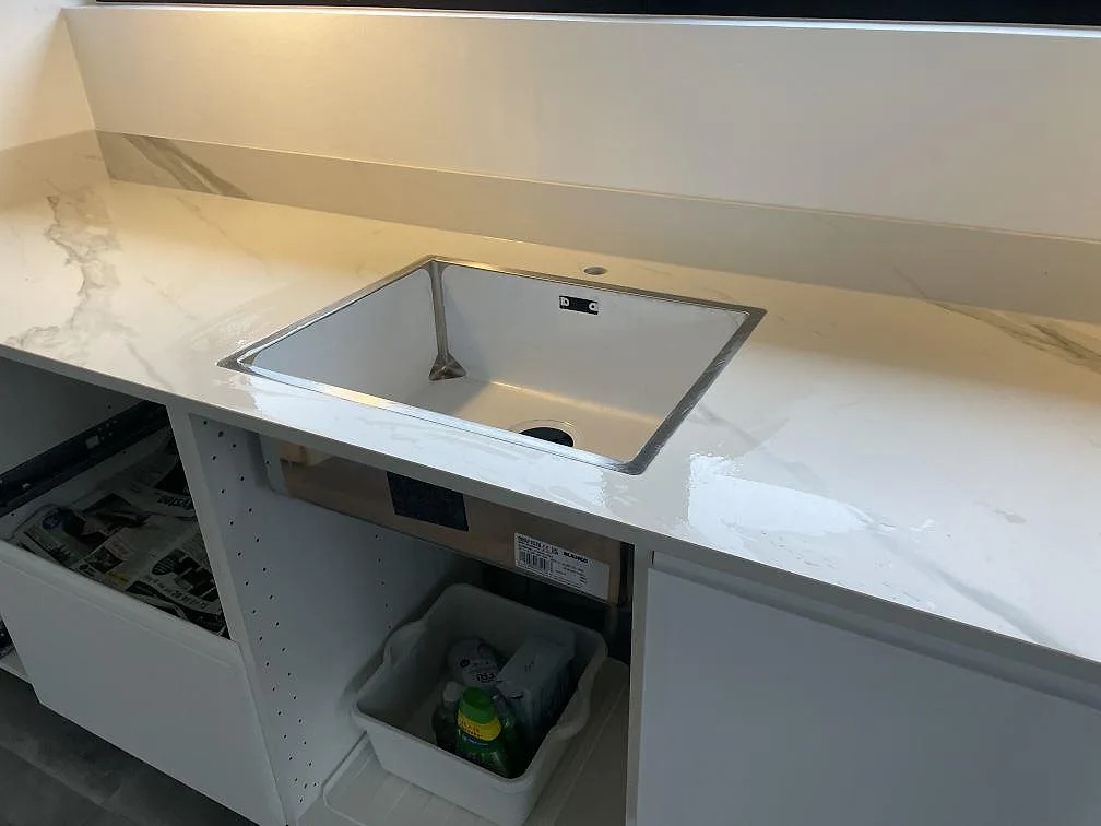 Närbild på matt Dekton Opera Velvet köksbänkskiva i keramik med rostfri diskho och 8 mm stänkkant i Solroed Strand.