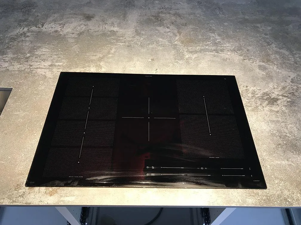 Svart induktionshäll på köksbänkskiva i Dekton Orix, matt mörk keramik, i ett kök i Sävedalen.