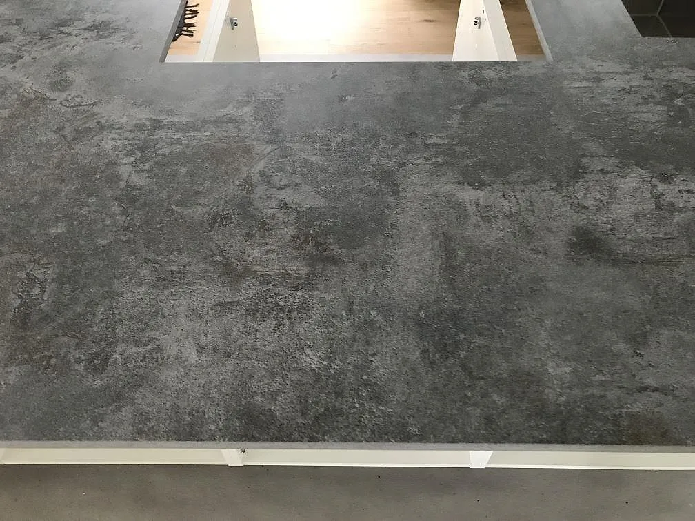 Köksbänkskiva i Dekton Orix med urtag för häll, matt betongliknande keramik, i ett kök i Sävedalen.