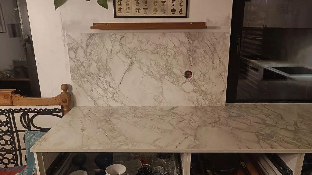 Marmorerad köksbänkskiva i matt Dekton Portum med väggskydd bakom arbetsytan i Malmö.