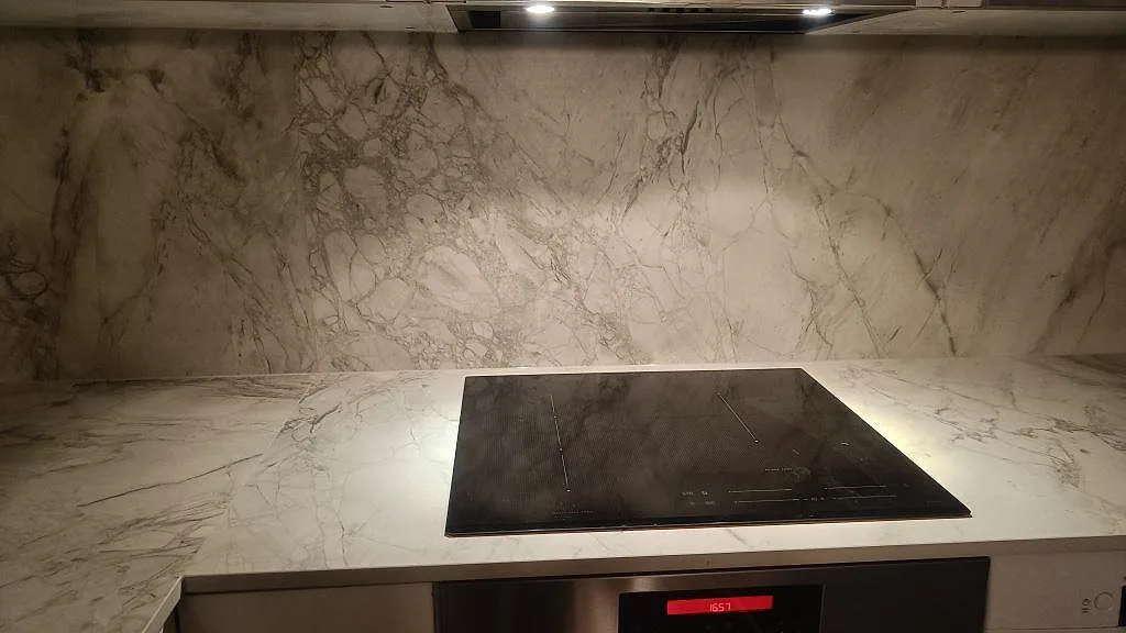 Svart häll monterad i matt Dekton Portum med matchande stänkvägg i Malmö.