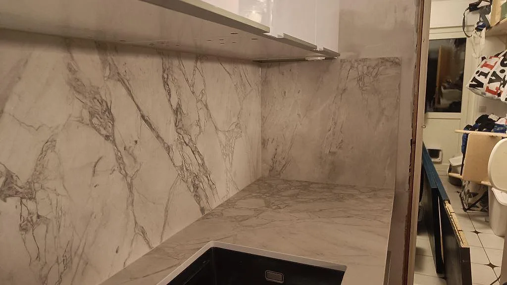 Matt Dekton Portum som bänkskiva och hög stänkvägg vid diskhon i ett kök i Malmö.
