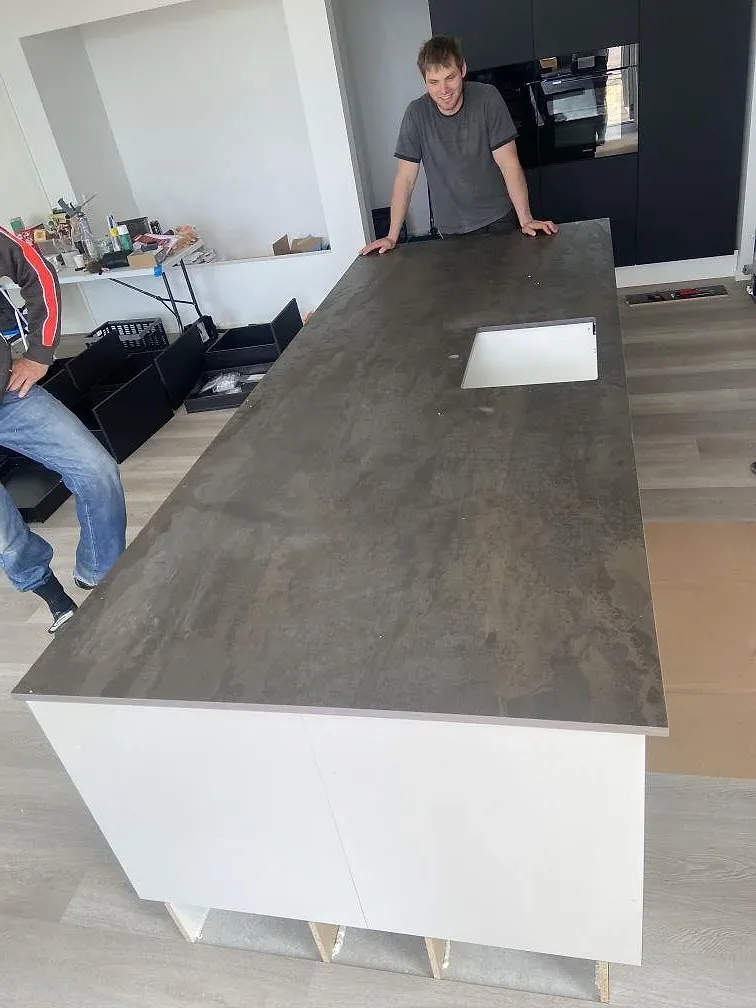 Köksbänkskiva i matt Dekton Radium på vita köksstommar under montering i Bramming.