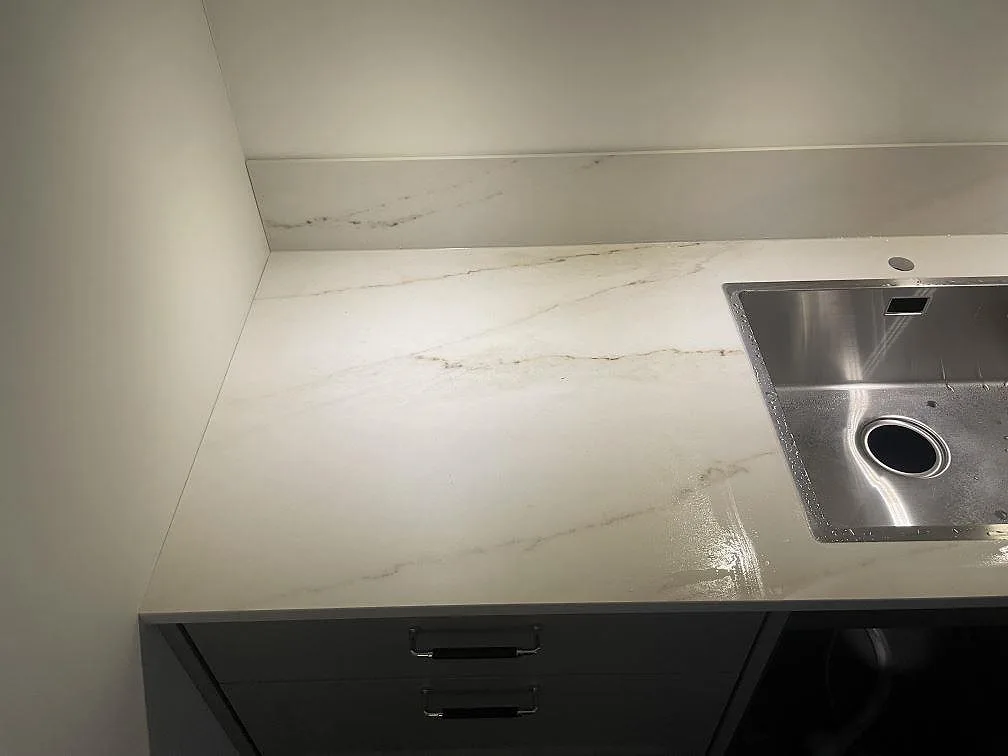 Arbetsyta i Dekton Rem (Velvet), matt keramik, med ljus marmorering vid en rostfri diskho i ett kök i Åskloster.