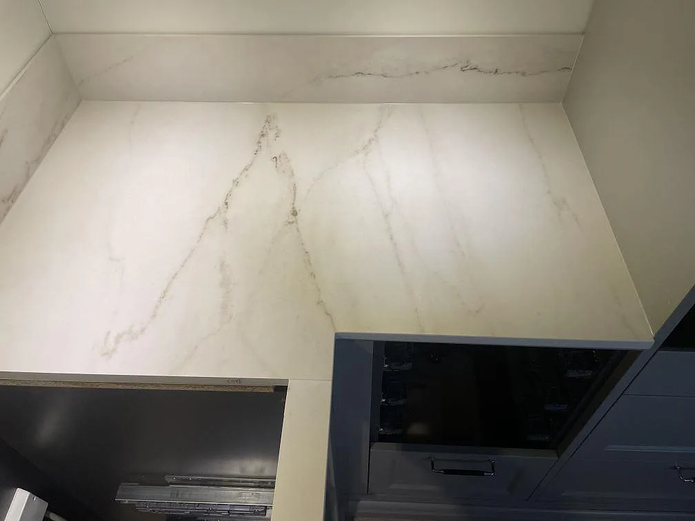 Topvy av Dekton Rem (Velvet), matt keramik, med stänkskydd, bänkskiva och ljus ådring i köket i Åskloster.