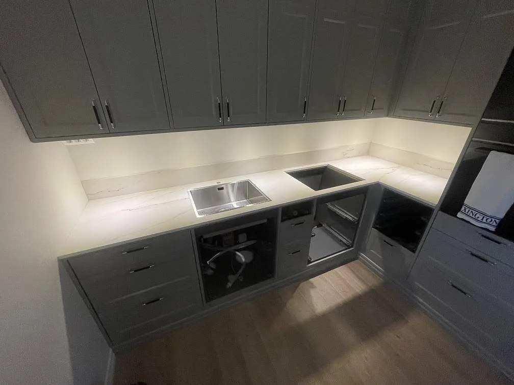 Köksbänkskiva i Dekton Rem (Velvet), matt keramik, med rostfri diskho, hälluttag och stänkskydd i ett kök i Åskloster.
