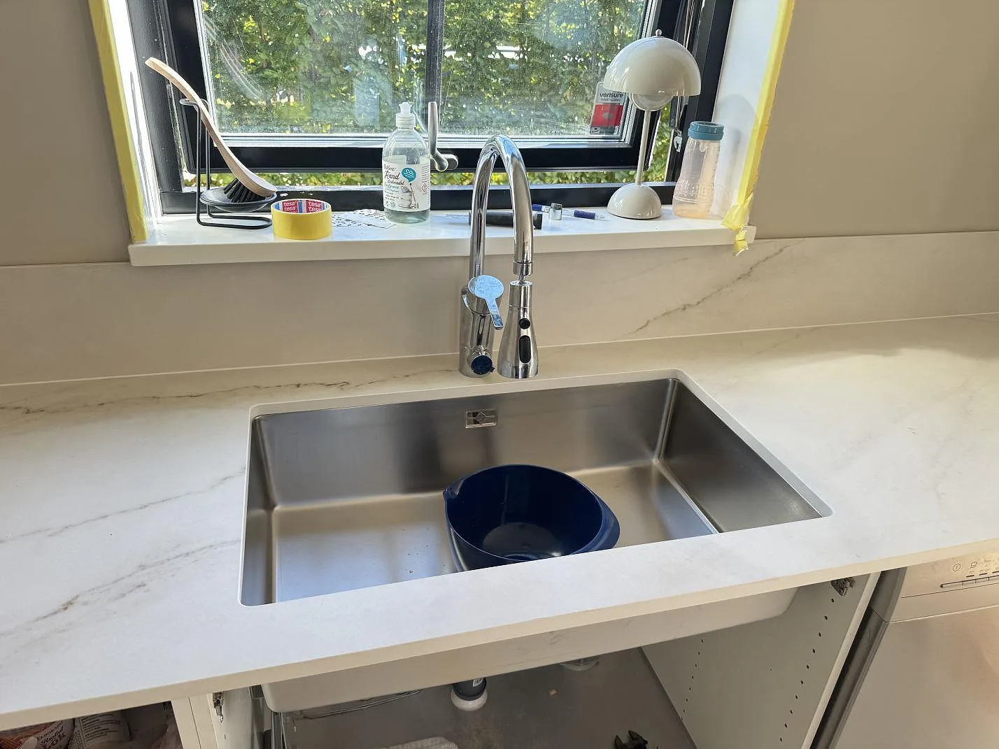 Köksbänkskiva i matt Dekton Rem (Velvet), keramik, med underlimmad rostfri diskho och lågt stänkskydd under fönster i Båstad.